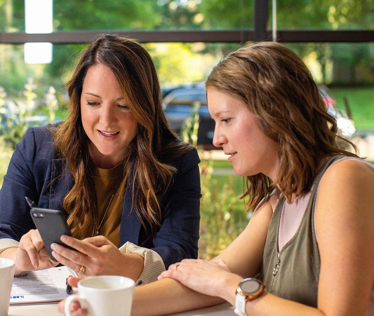 Women looking on their phone for new leads coming into their business
